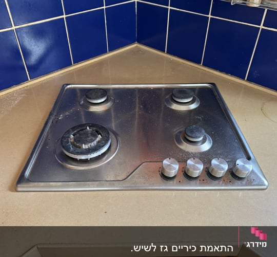 כיריים על משטח שיש במטבח עם אריחים כחולים